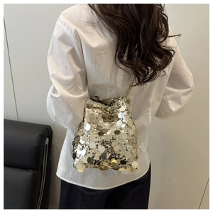 Detailed view of women's bucket bag with large metallic sequins and chain strap