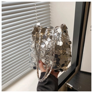 Détail du sac seau à paillettes argentées avec chaîne métallique et bandoulière en cuir