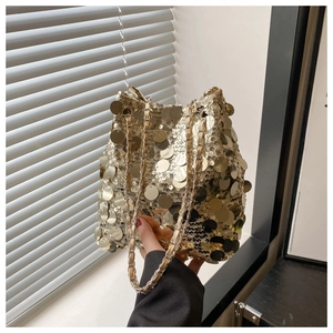 Détail de paillettes dorées scintillantes et bandoulière chaîne sur un sac seau