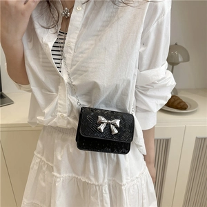 Mini black crossbody bag with snake pattern and silver bow on elegant chain strap
