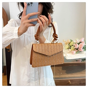 Détail de la texture en paille tressée et de la poignée en cuir de ce sac chic
