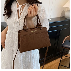 Brown crocodile embossed leather handbag with dual handles and gold fashion lettering