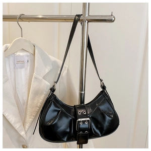Détail du sac sous le bras en cuir verni noir avec design plissé et boucle argent