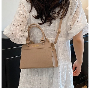 Chic khaki faux crocodile texture bag with gold FASHION BAG lettering on white dress