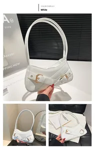 Close-up of white crocodile pattern leather handbag with elegant gold metal buckle detail