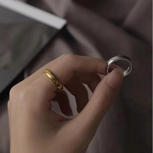Polished minimalist stainless steel rings in gold and silver finish shown on hand