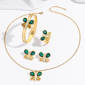 Parure bijoux papillon dorée avec cristaux émeraude et détails ciselés sur soie