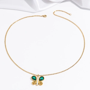 Vue détaillée du collier papillon doré avec des pierres vert émeraude et des cristaux