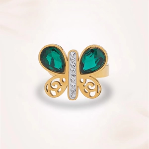 Détail de la bague papillon dorée avec pierres vert émeraude et incrustations de zircon