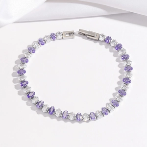 Detail of tennis bracelet featuring alternating purple and clear oval-cut cubic zirconia stones