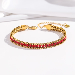 Detailed shot of golden chain bracelet with prong-set red cubic zirconia and lobster clasp