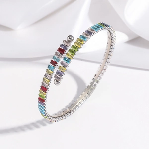Detail of silver stainless steel open bangle with colorful rectangular zircon stones