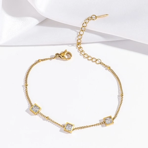 Vue macro d'un bracelet doré avec trois pierres de zircon à la coupe carrée élégante