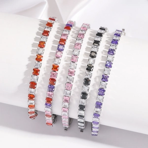 Cinq bracelets tennis en zircon coupe princesse de couleurs variées sur un présentoir