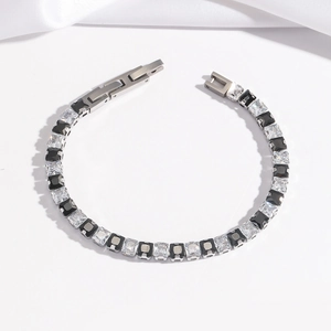 Détail d'un bracelet en acier argenté avec incrustation de zircons noirs et blancs