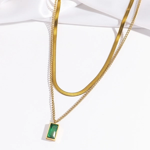 Close-up of double-layer gold necklace featuring a green emerald-cut zircon pendant