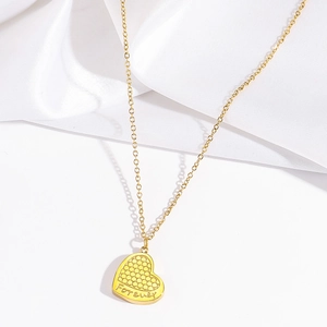 Detailed close-up of golden heart pendant with honeycomb texture and Forever engraving