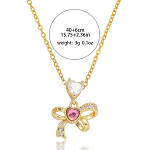 Collier doré avec pendentif papillon, pierre rose en cœur et détails en zircone cubique