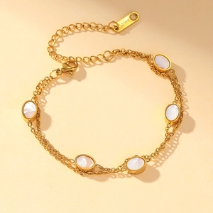 Golden double-layer stainless steel bracelet with oval shell charms on yellow background