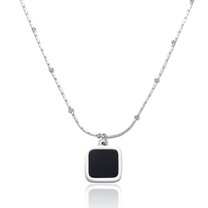 Detail of silver chain necklace with square black pendant and beaded link accents