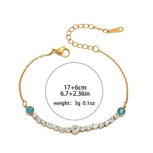 Gold titanium bracelet featuring light blue gems and round clear rhinestones