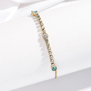 Detail of gold titanium steel bracelet featuring blue gems and clear crystal inlay
