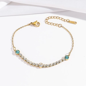Elegant gold titanium steel bracelet with gradient blue and white crystals in a flat lay view