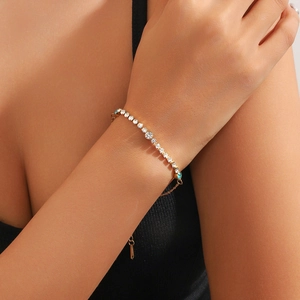 Elegant gold plated tennis bracelet with sparkling blue and clear crystals on female wrist