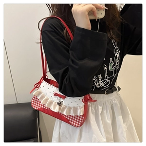 Nahaufnahme der roten karierten Schultertasche mit gepunkteter Klappe und Seidenrüschen