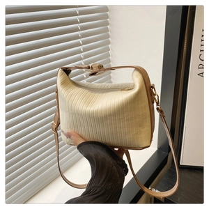 Détail du sac bandoulière beige plissé avec fermeture éclair dorée et lanières brunes