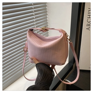 Vue détaillée du sac à main rose à texture verticale avec boucle en métal doré
