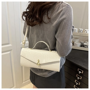 Détail du sac blanc crème effet crocodile avec fermoir note de musique dorée et bandoulière