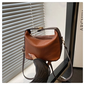 Détail du sac à main plissé en similicuir caramel avec finitions dorées et poignée top