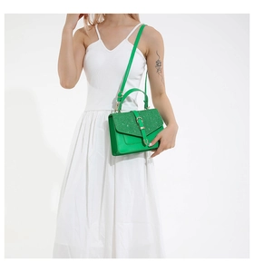 Détail du sac à main vert vif avec finition pailletée et garnitures métalliques dorées