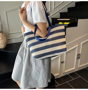 Detailed texture of blue and white striped tote bag with sturdy navy blue handle