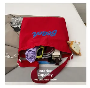 Interior view showing large capacity storage for daily essentials in red canvas tote bag