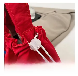 Detail of red nylon tote bag featuring adjustable white drawstring with a clear plastic toggle