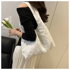 Detail of white floral tote bag with yellow embroidery and cutout fabric texture