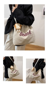 Detail of canvas tote bag with purple Beach text and cute toast plush pendant