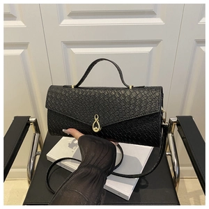 Detail of black crocodile texture bag with elegant golden teardrop metal clasp