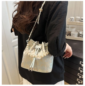 Detailansicht hellgrüne Jacquard Beuteltasche mit Goldstickerei und Perlen Tragegriff