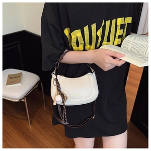 Dettaglio della borsa in pelle PU bianco avorio con logo dorato e ciondolo da baseball