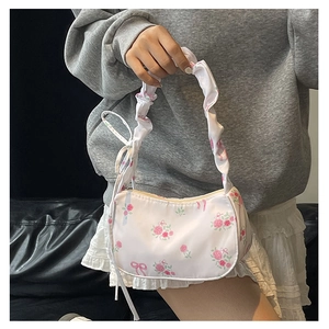 Detail of floral handbag featuring ruched cloud handle and elegant side ribbons