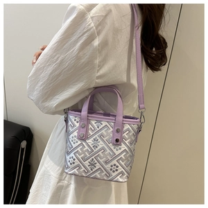 Detail view of the lavender bucket bag showing intricate floral embroidery and geometric patterns