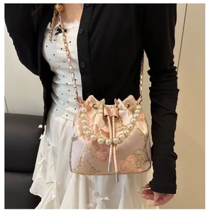Detail der rosa Jacquard-Beuteltasche mit Perlengriff und Seidenstickerei