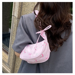 Detail of pink floral shoulder bag with ruched drawstrings and ribbon patterns