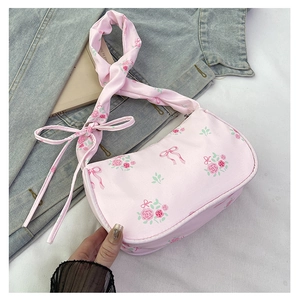 Close-up of pink floral shoulder bag with rose patterns, bow details and zipper closure