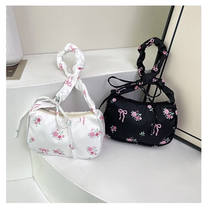 Close-up of black and white floral hobo bags with pleated straps and rose prints