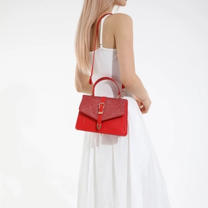 Sac à main chic en cuir rouge avec rabat scintillant et boucle dorée sur modèle