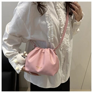 Detail of pink pleated bucket bag with soft PU leather and white plush charm accessory